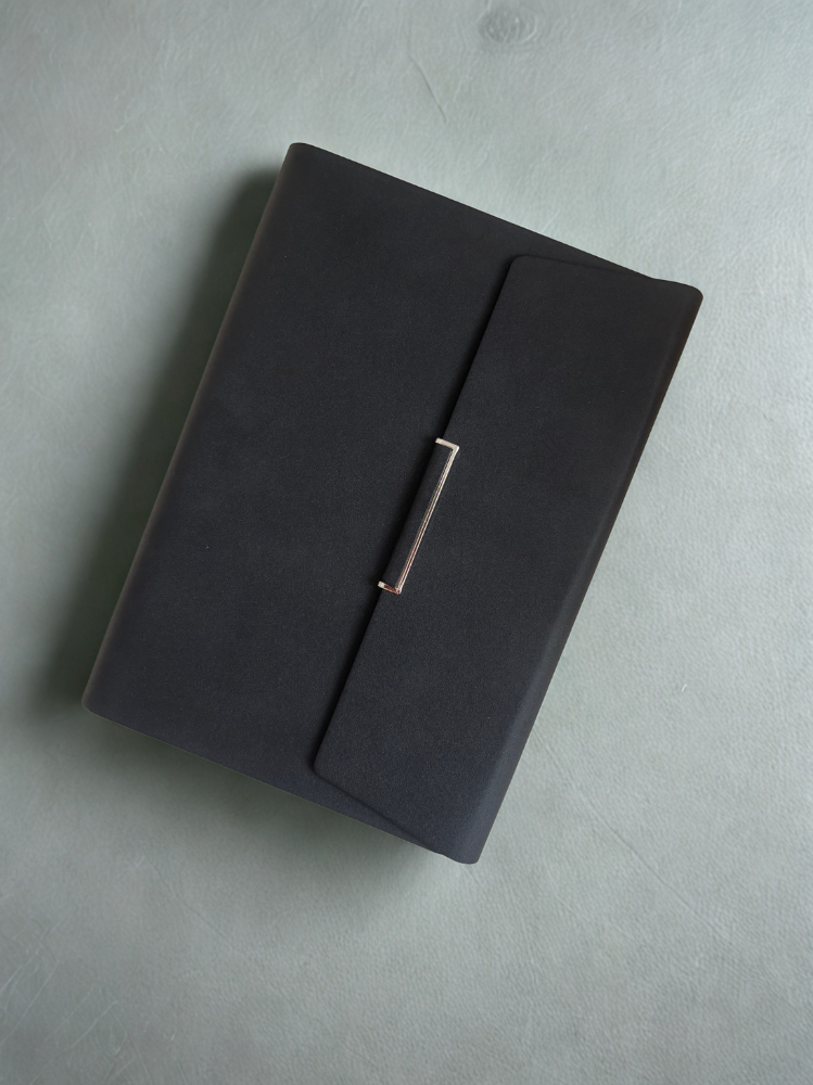 Agenda noir posé sur un fond clair, élégant et professionnel