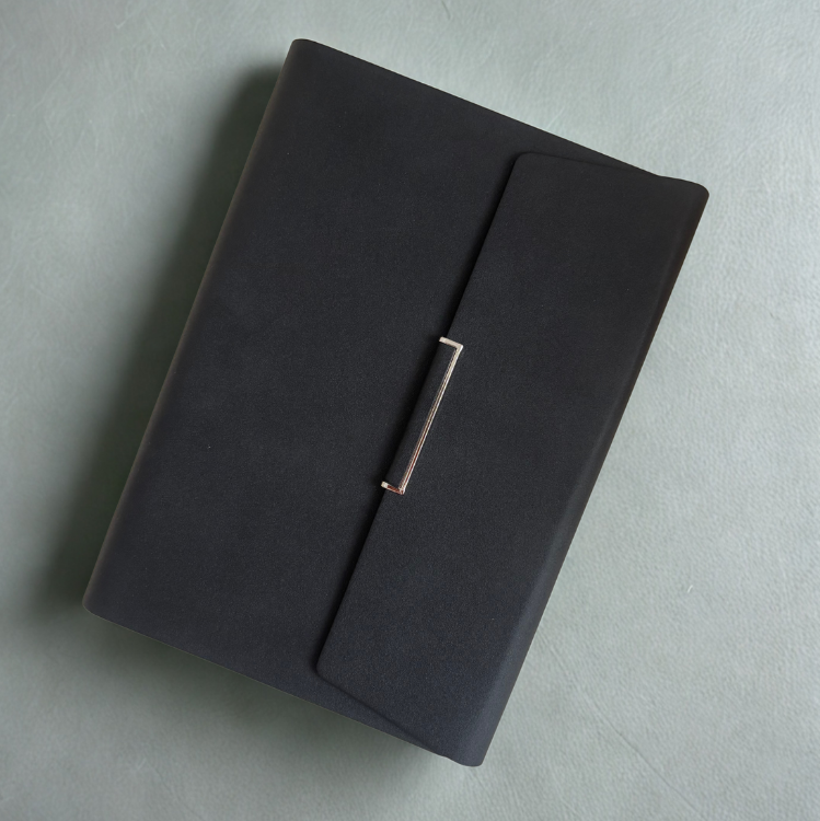 Agenda noir posé sur un fond clair, élégant et professionnel